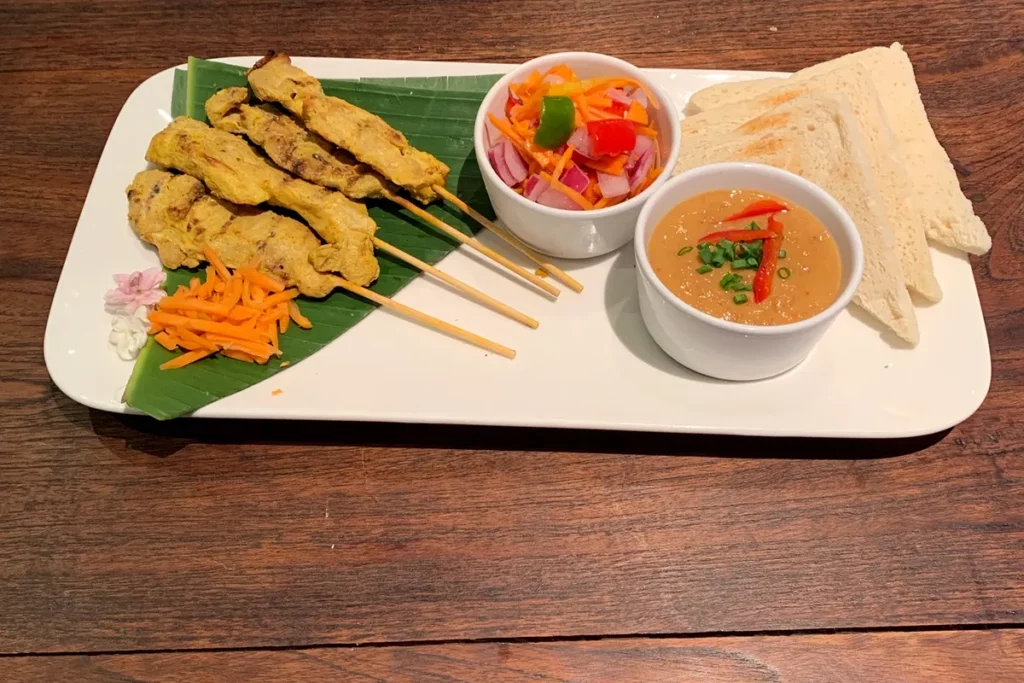 Brochettes de poulet thaïlandaises servies avec une sauce satay maison