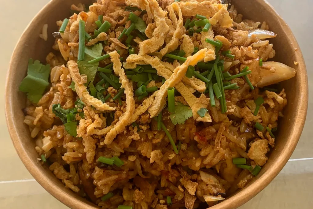 Riz frit thaïlandais garni d’herbes fraîches et préparé au wok